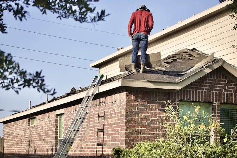 Professional roofer working on a residential roof in Buddtown